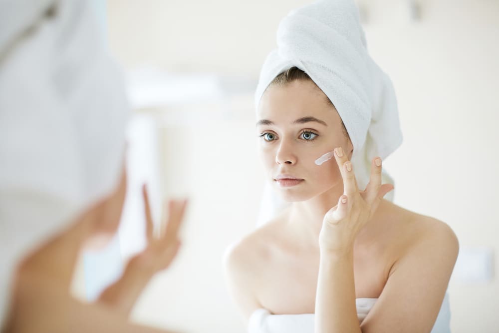 women applying sunscreen to her face